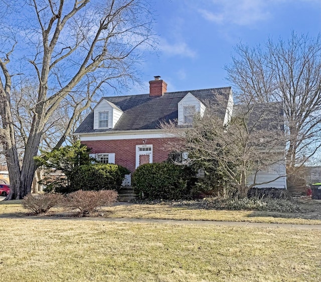 view of home's exterior featuring a yard, brick siding, and a chimney