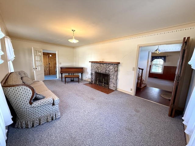 living area featuring a stone fireplace, crown molding, and carpet floors