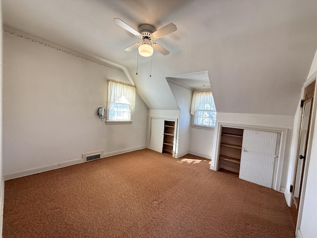 additional living space featuring carpet flooring, a healthy amount of sunlight, visible vents, and lofted ceiling