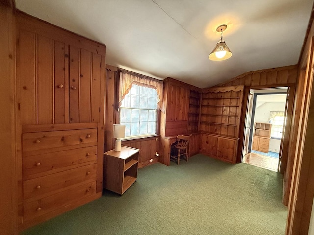 home office featuring vaulted ceiling, wooden walls, and light colored carpet