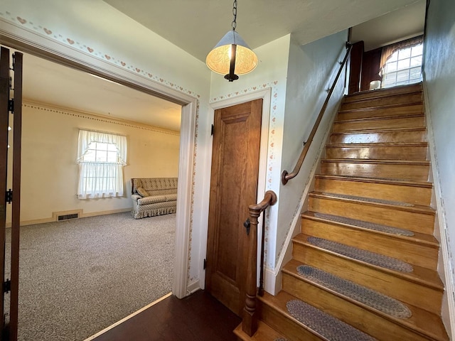 stairway with visible vents, baseboards, and carpet