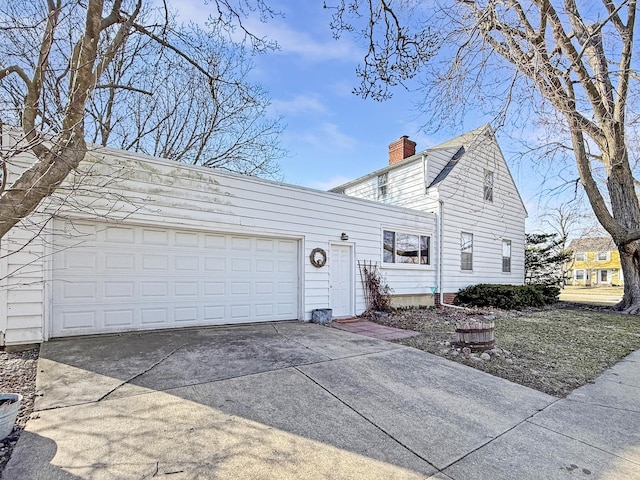 exterior space with driveway, a chimney, and a garage