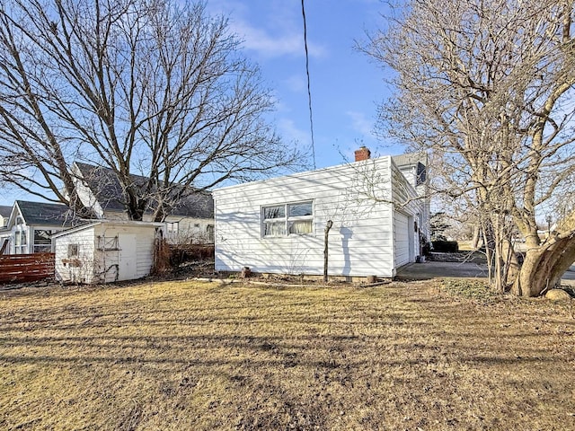 view of property exterior with an outbuilding, a garage, and a chimney