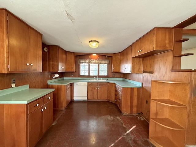 kitchen featuring open shelves, a sink, brown cabinetry, white dishwasher, and brick floor