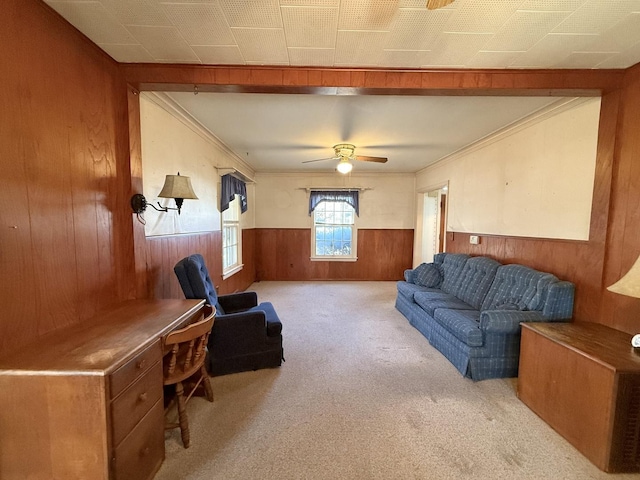 living area featuring a wainscoted wall, carpet, ornamental molding, and wood walls