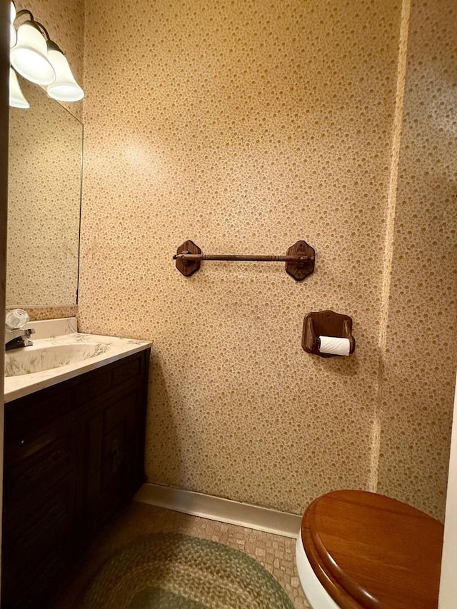 half bath featuring vanity, tile patterned floors, and baseboards