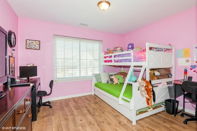 bedroom with visible vents, baseboards, and wood finished floors