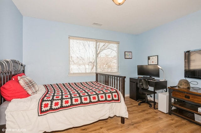 bedroom featuring visible vents and wood finished floors