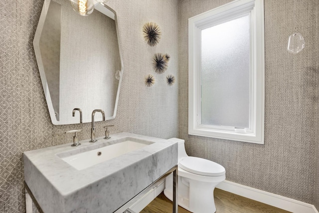 bathroom featuring wallpapered walls, vanity, toilet, and wood finished floors