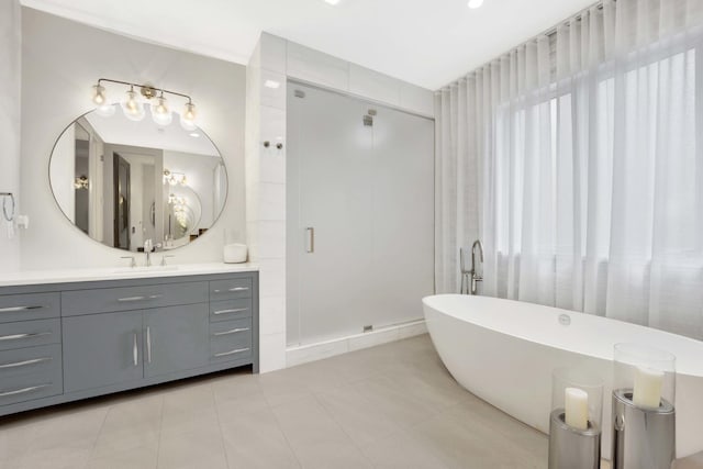 full bath featuring vanity, a shower stall, a soaking tub, and tile patterned flooring