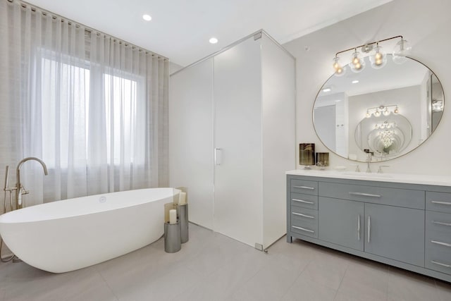 full bathroom featuring tile patterned floors, recessed lighting, vanity, and a freestanding tub