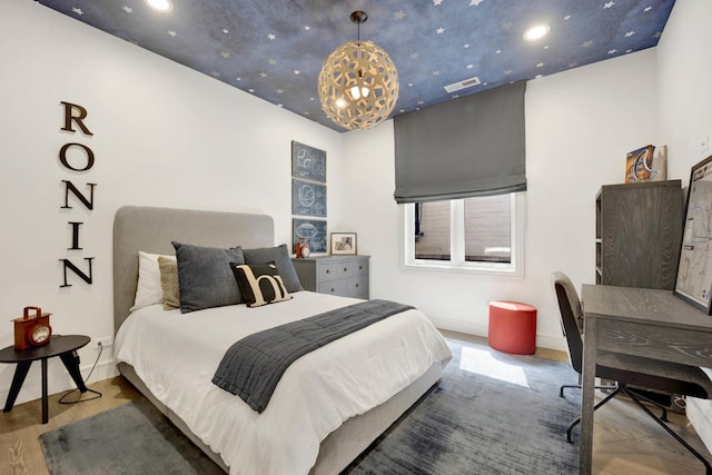 bedroom with visible vents, baseboards, and wood finished floors