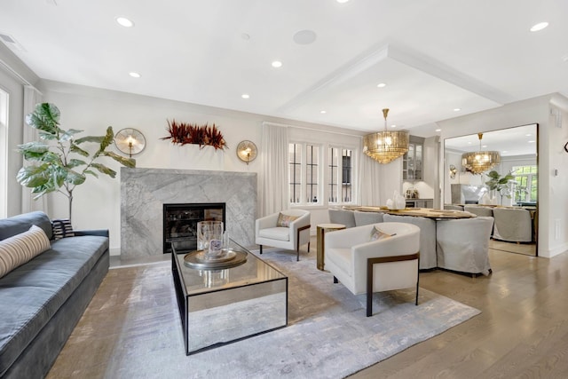 living room with recessed lighting, a fireplace, light wood-style floors, and a chandelier