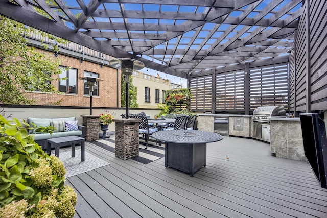 wooden terrace with beverage cooler, a pergola, an outdoor living space, a grill, and an outdoor kitchen