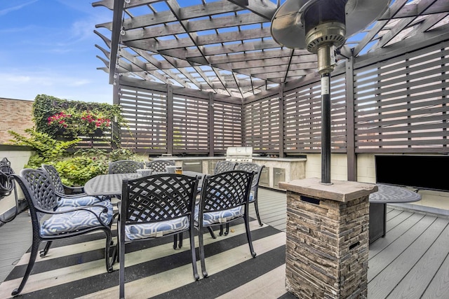 wooden terrace featuring exterior kitchen, outdoor dining area, a pergola, and grilling area