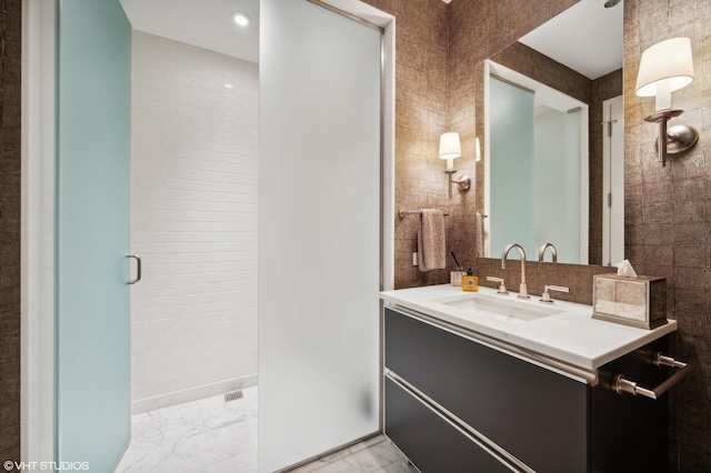 77 E Walton Pl Unit 24E, Chicago, IL 60611 - bathroom featuring vanity, marble finish floors, a stall shower, and tile walls