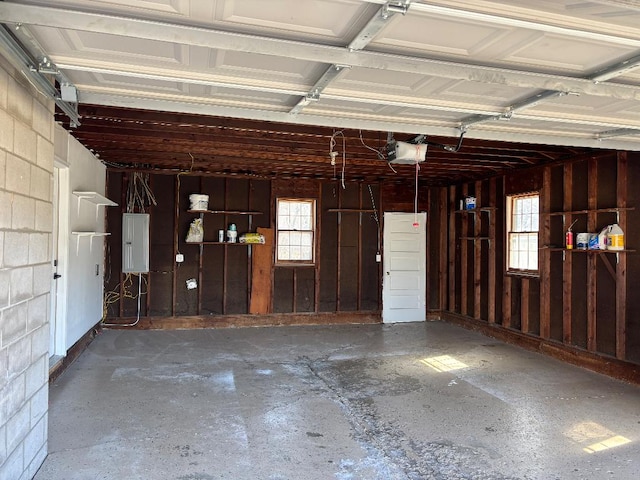 garage with electric panel and a garage door opener