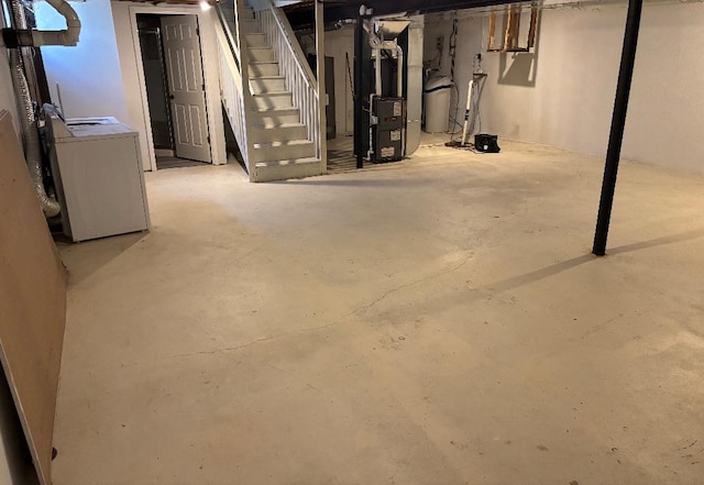 unfinished basement with heating unit and washer / dryer