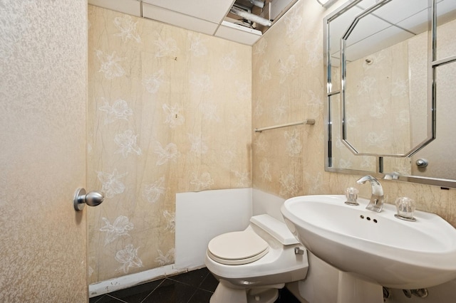 bathroom featuring a sink, toilet, and tile patterned flooring