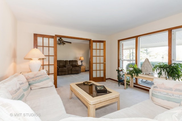 living area with french doors, a ceiling fan, and carpet