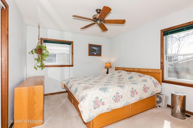 carpeted bedroom with a ceiling fan and baseboards