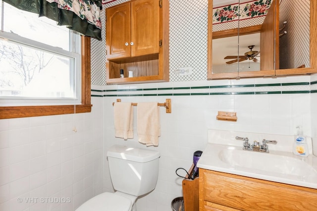 half bathroom with toilet, ceiling fan, and vanity