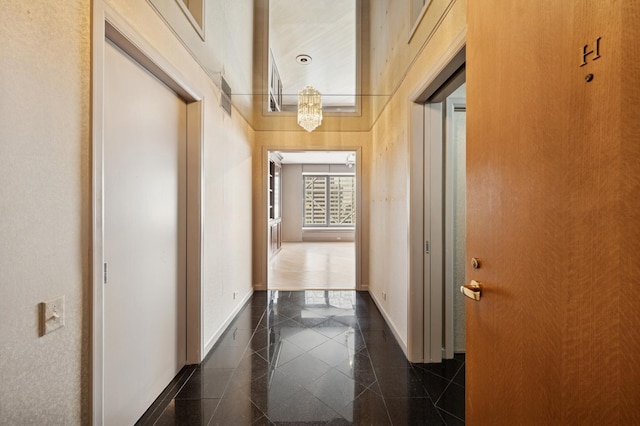 hallway with granite finish floor and baseboards