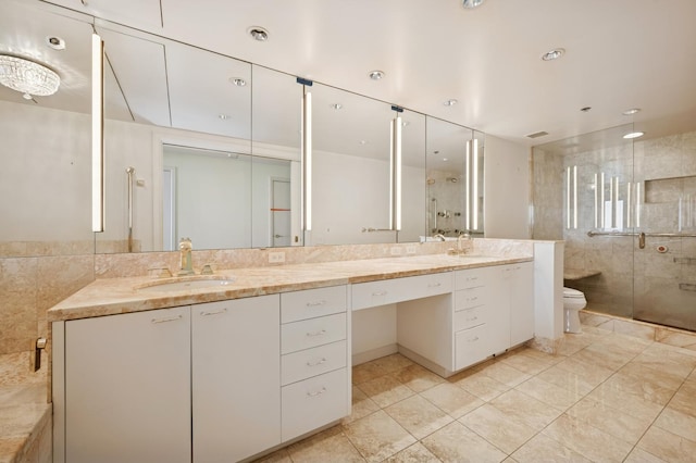 full bathroom with a shower stall, toilet, double vanity, and a sink