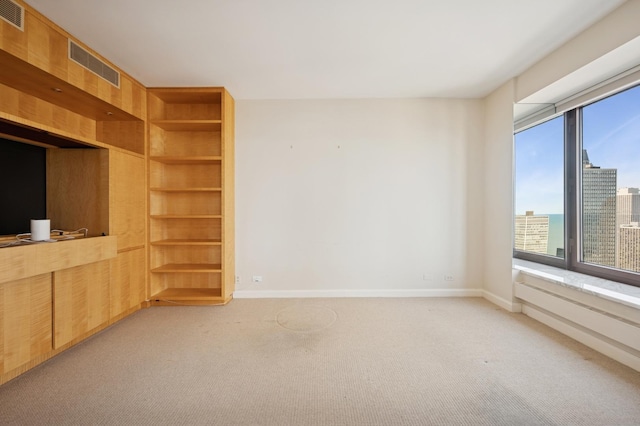 unfurnished living room with light carpet, visible vents, and baseboards