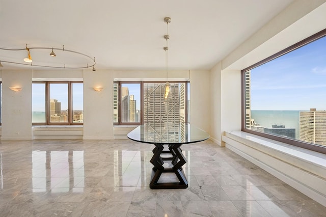 unfurnished dining area featuring baseboards, a view of city, and marble finish floor