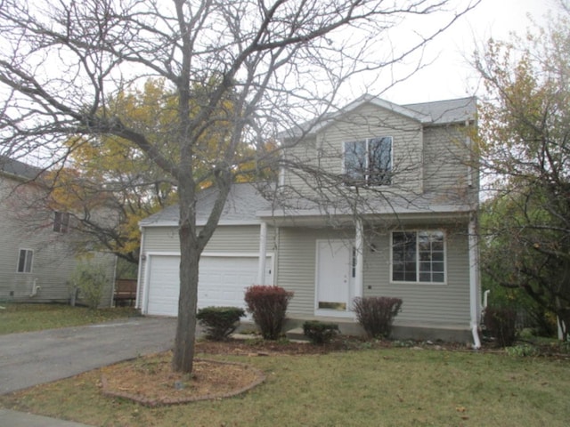 traditional-style home featuring aphalt driveway, an attached garage, and a front yard