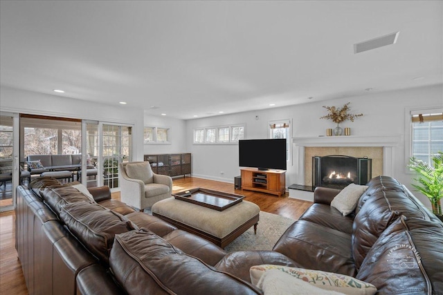 living area featuring visible vents, wood finished floors, a high end fireplace, recessed lighting, and baseboards