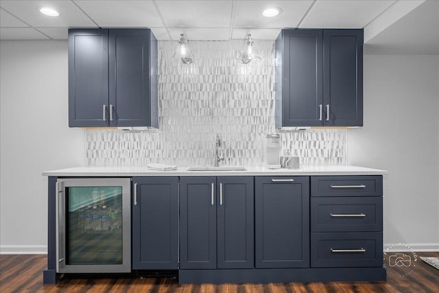 bar with a sink, indoor wet bar, wine cooler, and tasteful backsplash