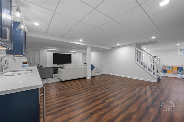 unfurnished living room with stairs, dark wood-type flooring, baseboards, and a sink