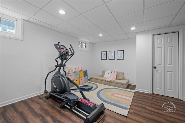 exercise room featuring recessed lighting, a drop ceiling, baseboards, and wood finished floors