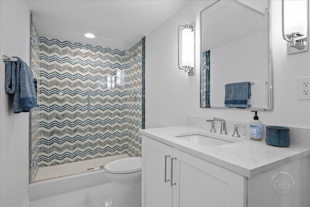 bathroom featuring toilet, a stall shower, and vanity