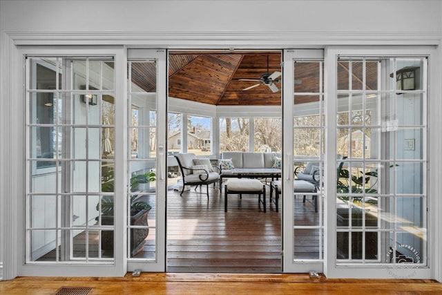 unfurnished sunroom with lofted ceiling, wooden ceiling, and ceiling fan