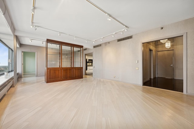 spare room with visible vents, a chandelier, and light wood finished floors