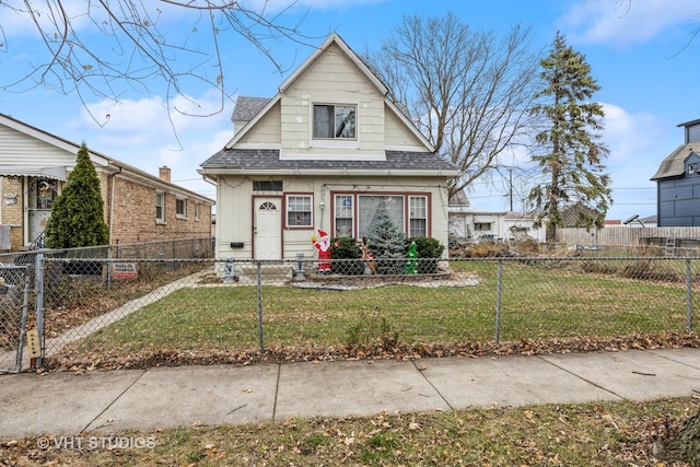 bungalow-style house featuring a fenced front yard, a front lawn, and a shingled roof