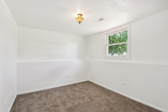 carpeted spare room featuring visible vents and baseboards