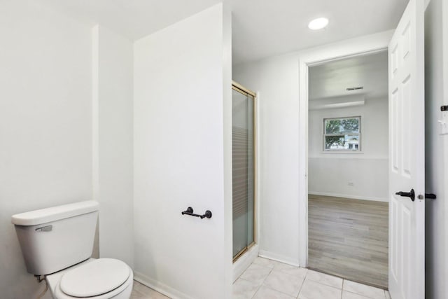 full bathroom featuring tile patterned flooring, a stall shower, toilet, and baseboards