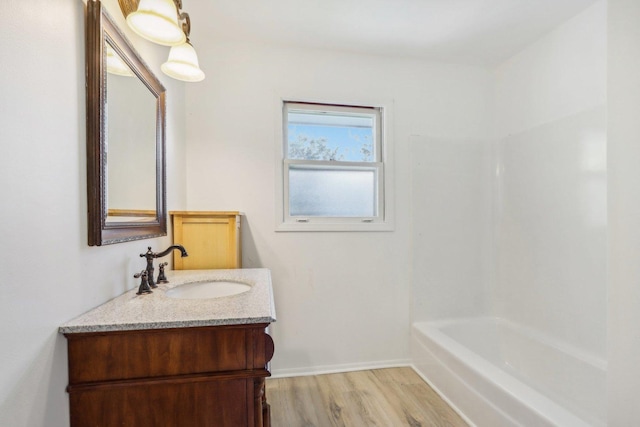 bathroom with baseboards, wood finished floors, and vanity