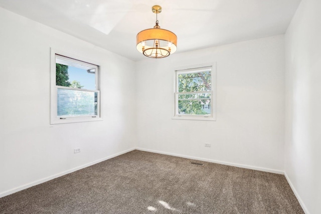 carpeted empty room with visible vents and baseboards