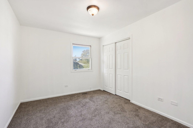 unfurnished bedroom with a closet, baseboards, and carpet