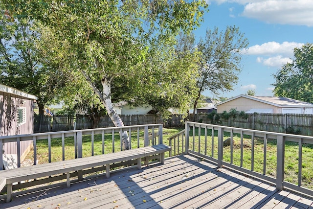 wooden deck featuring a fenced backyard and a lawn