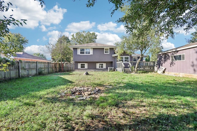 back of house featuring a wooden deck, a yard, and a fenced backyard