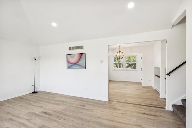 unfurnished living room featuring visible vents, recessed lighting, stairs, light wood-type flooring, and a chandelier