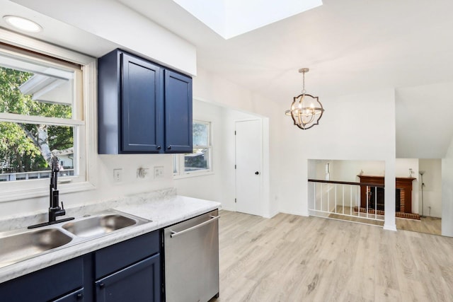 kitchen with a sink, blue cabinets, dishwasher, and light countertops