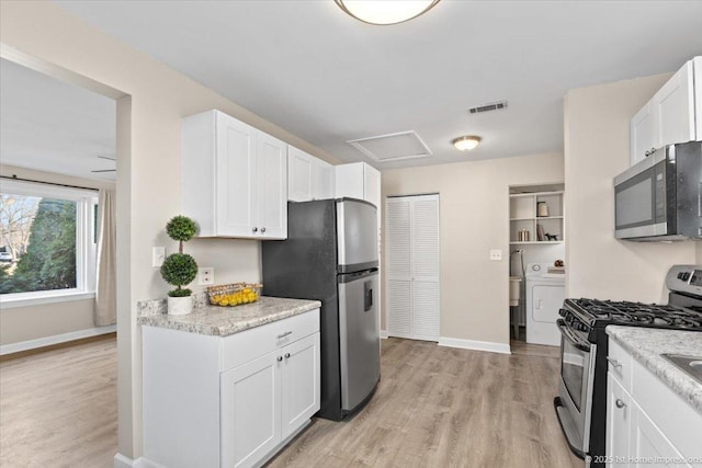 kitchen featuring light wood-type flooring, visible vents, washer / clothes dryer, white cabinetry, and stainless steel appliances