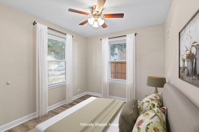 bedroom with light wood-type flooring, baseboards, and ceiling fan